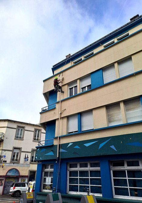 Cordiste en descente le long d'une façade d'immeuble